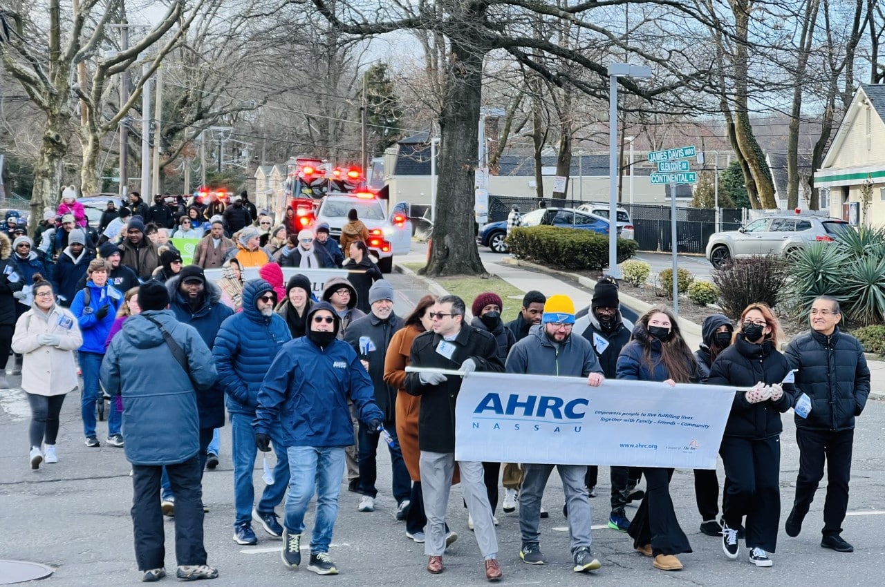Self-advocates and the community advocate for disability rights at a outdoor walk.