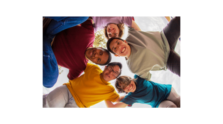 A group of people stand in a circle around camera