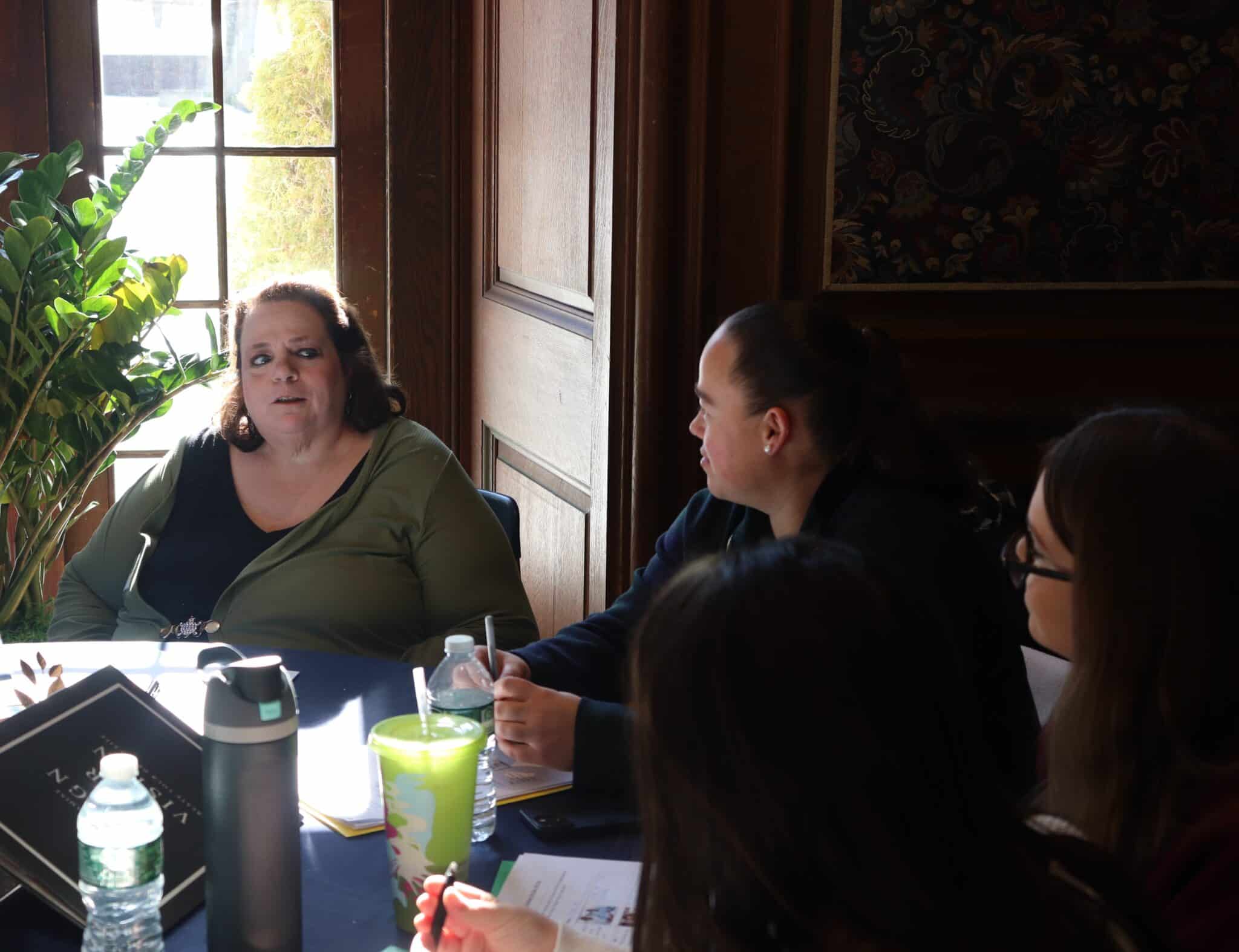 AHRC Nassau self-advocates and DSP Pathways students sit together at a table.