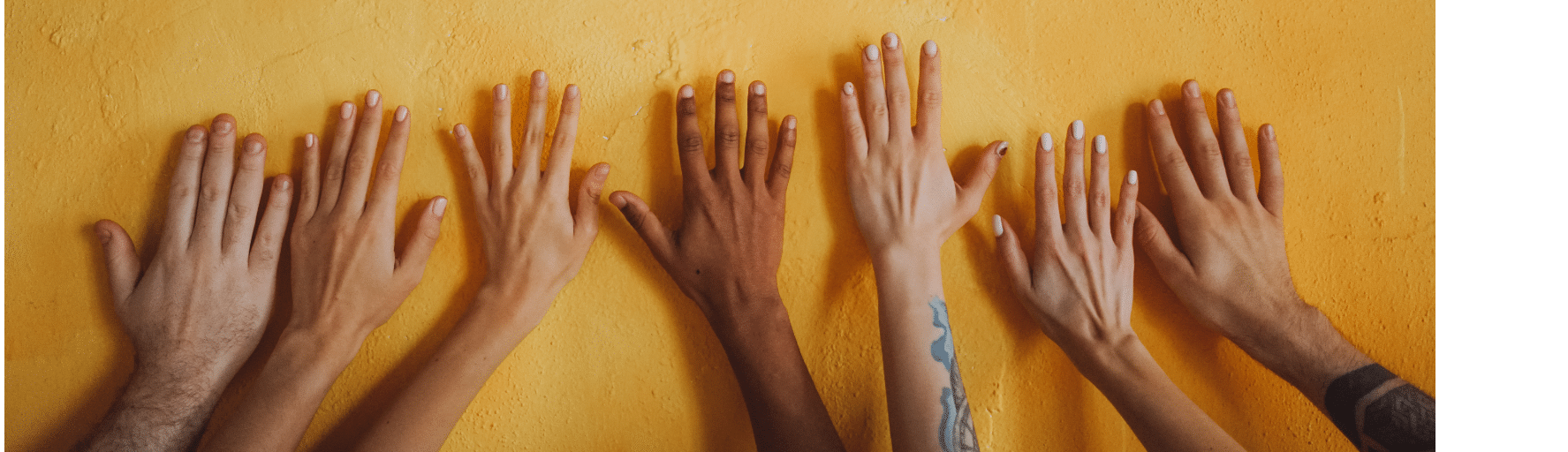 Hands against a yellow wall
