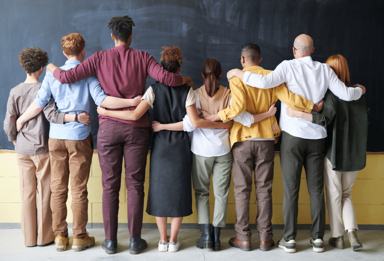 A group of people huddled together face away from the camera