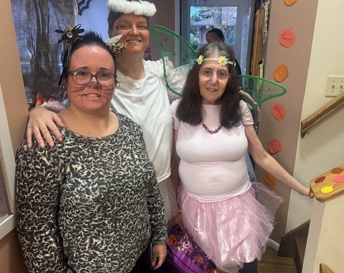 Three people supported by AHRC Nassau dressed as a cat, an angel, and a fairy for Halloween