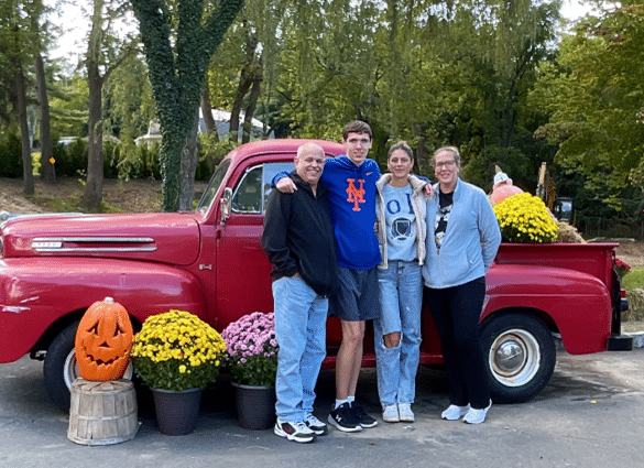 A family poses in front of a vintage truck at the Wheatley Farms Harvest Festival