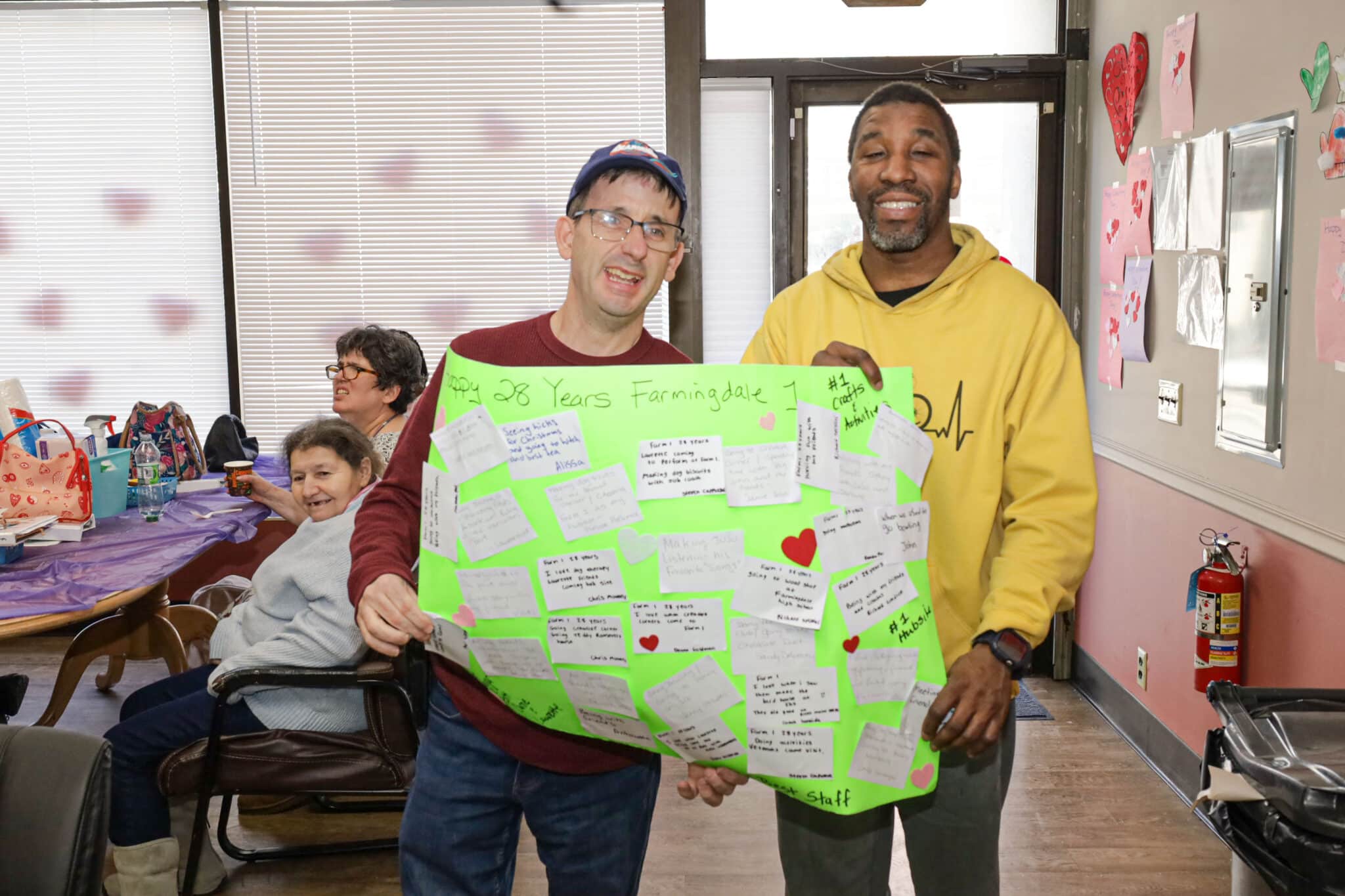 Residents of Farmingdale 1 hold up a sign they made for their anniversary celebration.
