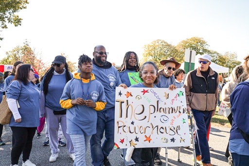 Attendees of the AHRC foundation Walk hold up a sign reading "The Plainview Powerhouse"