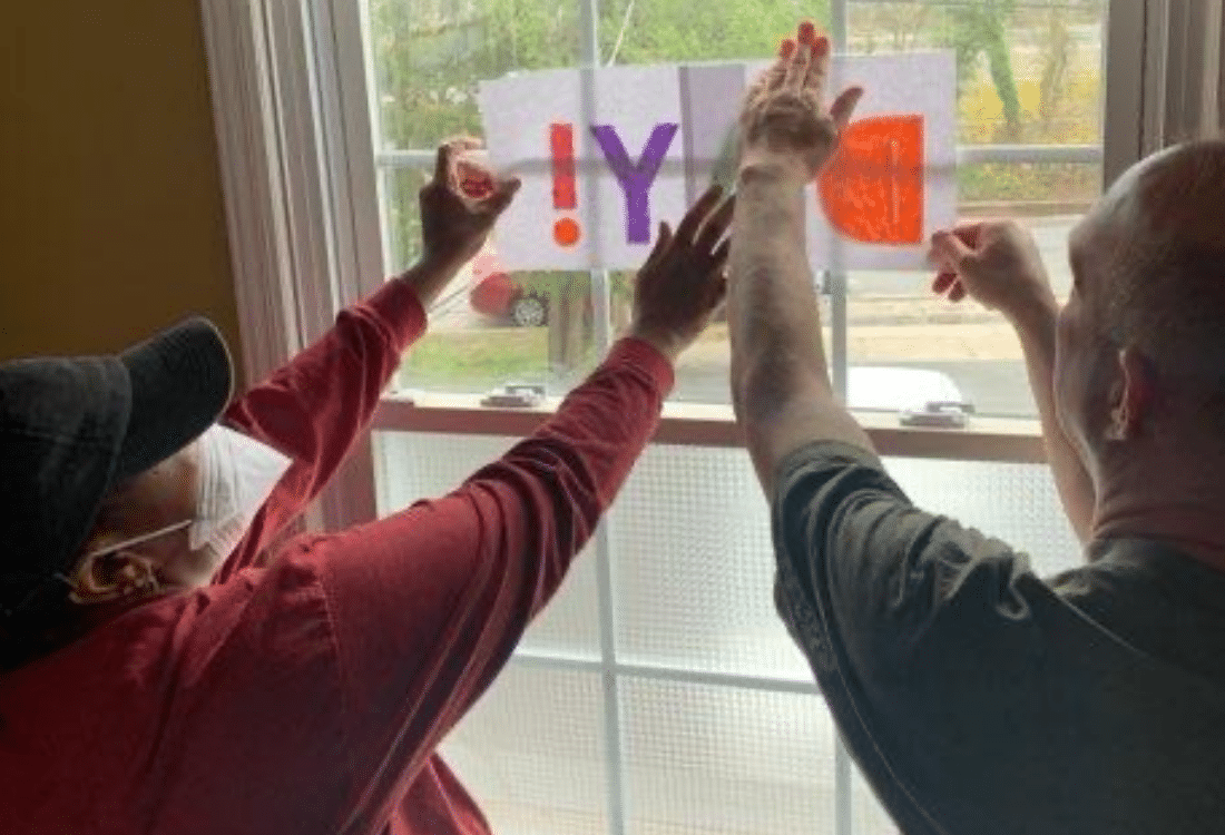 DSP helps a person with disabilities hang sign