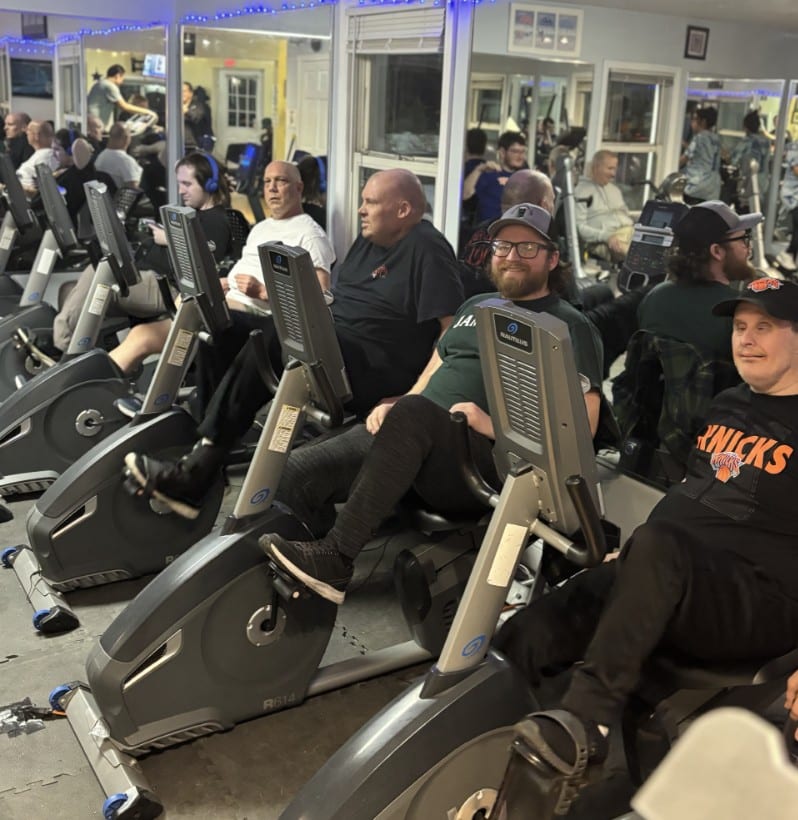 Residents of Old Britton ride stationery bikes together at HOPEFitness Sports Foundation