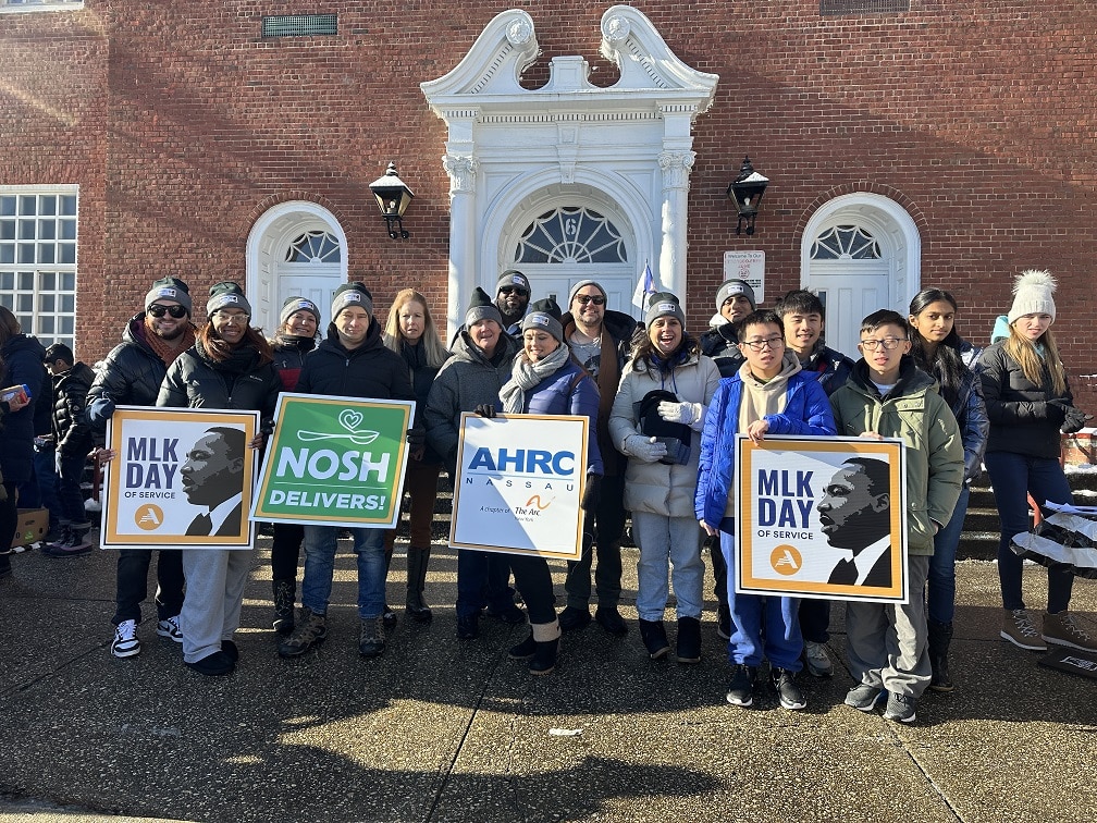 AHRC Nassau volunteers, staff, and members of the Glen Cove community holding signs for the 41st Annual Commemorative Program in Honor of Rev. Dr. Martin Luther King, Jr.