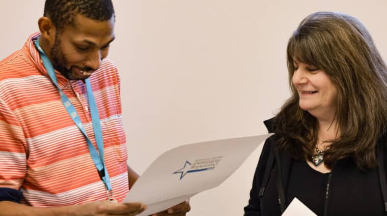 Cathy Hawkins gives Jeffrey Jean-Pierre his NYSID Outstanding Performance Award