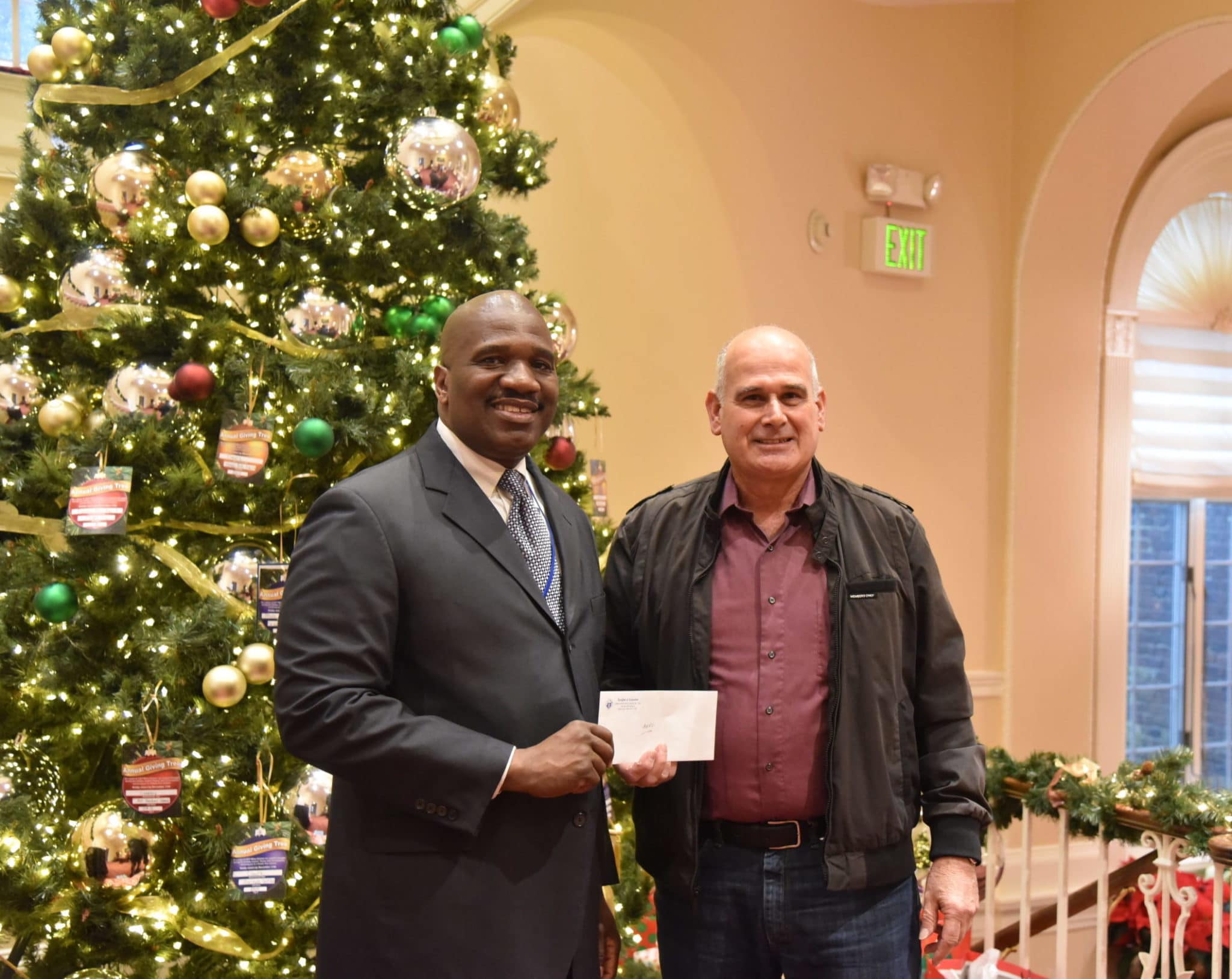 Knights of Columbus' Richie Alois presents check to Executive Director Stanfort Perry