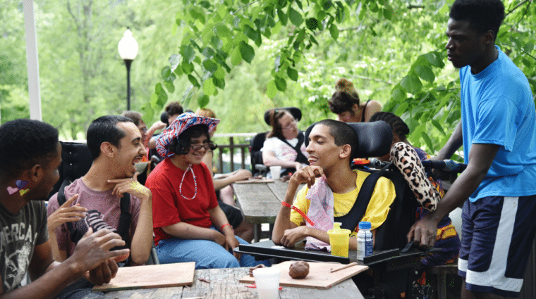 A group of people of all abilities enjoy each other's company at Camp Loyaltown