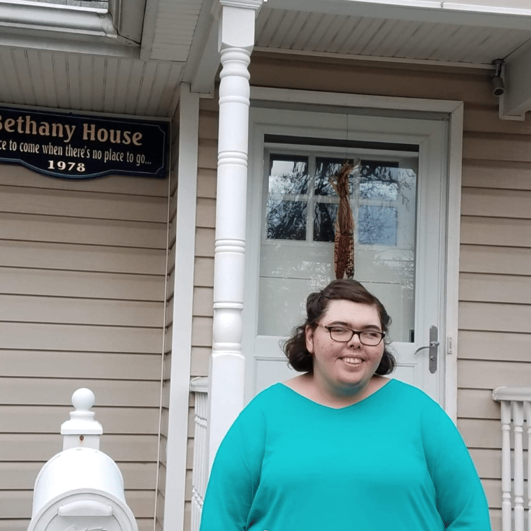 Amanda Brosnan smiles as she stands in front of Bethany House, a non-profit supporting homeless families in Nassau County