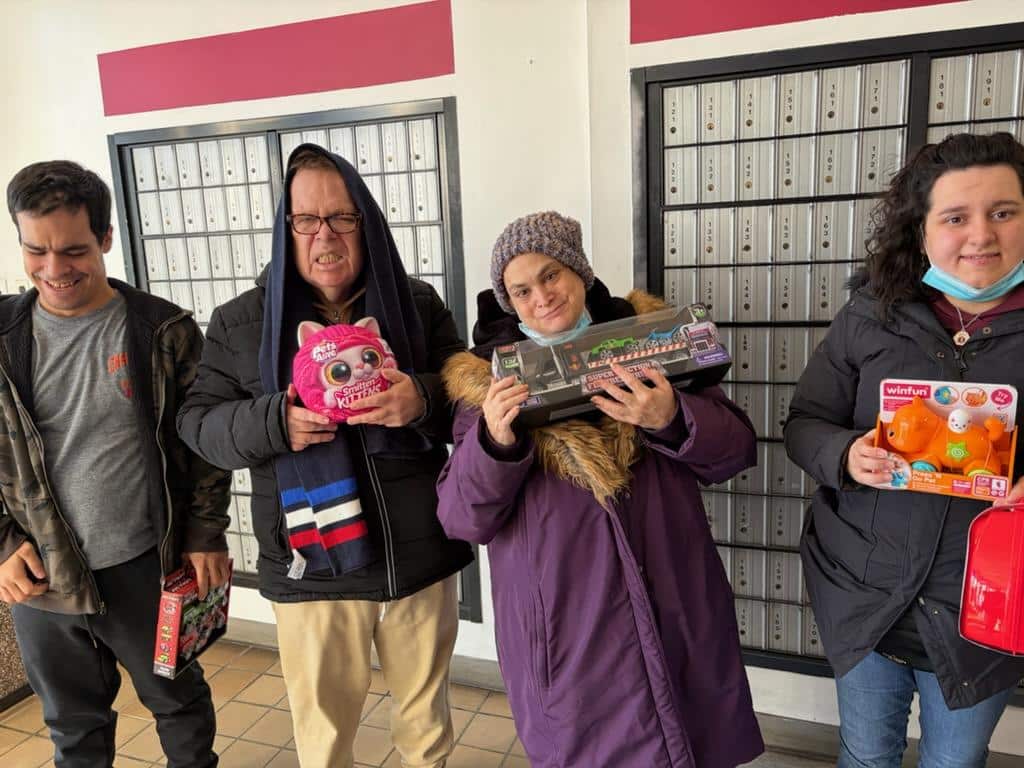 People supported by AHRC Nassau show hold toys they collected for Toys for Tots