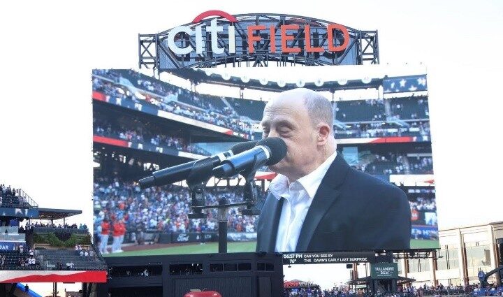 Adam Levine on the screen at Citi Field singing the National Anthem.