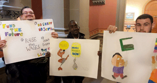 Advocates hold up signs advocating for