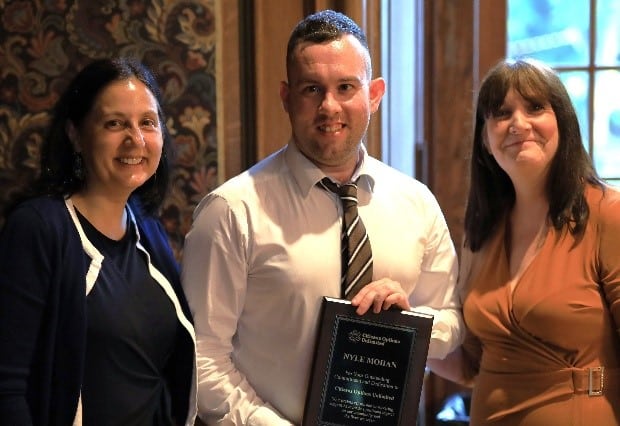 Jerri Walker, Nyle Mohan, and another volunteer pose with Nyle's award at the volunteer dinner