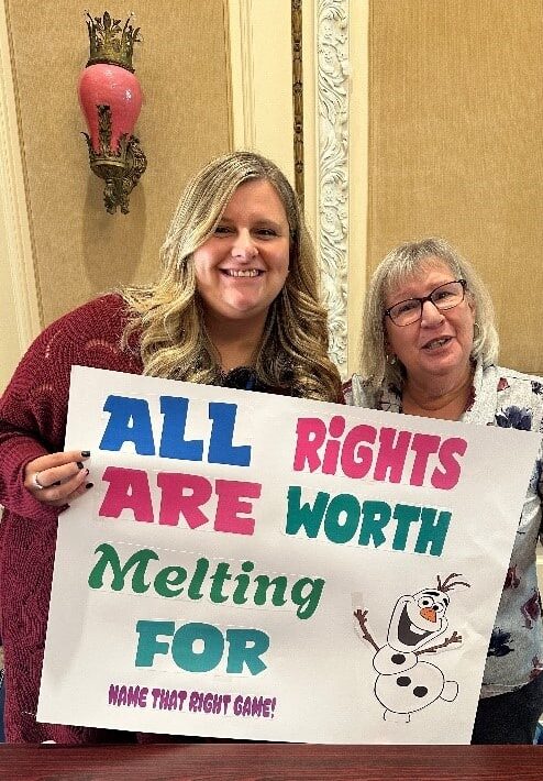 Self-advocates pose with signs at the rights rally