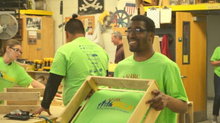 A member of the AHRC Nassau Farmingdale Day Hab team carries a completed dog bed to be donated to local animal shelters.