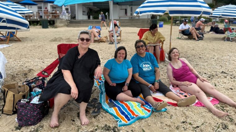 People supported by AHRC Nassau and DSPs enjoy the beach.