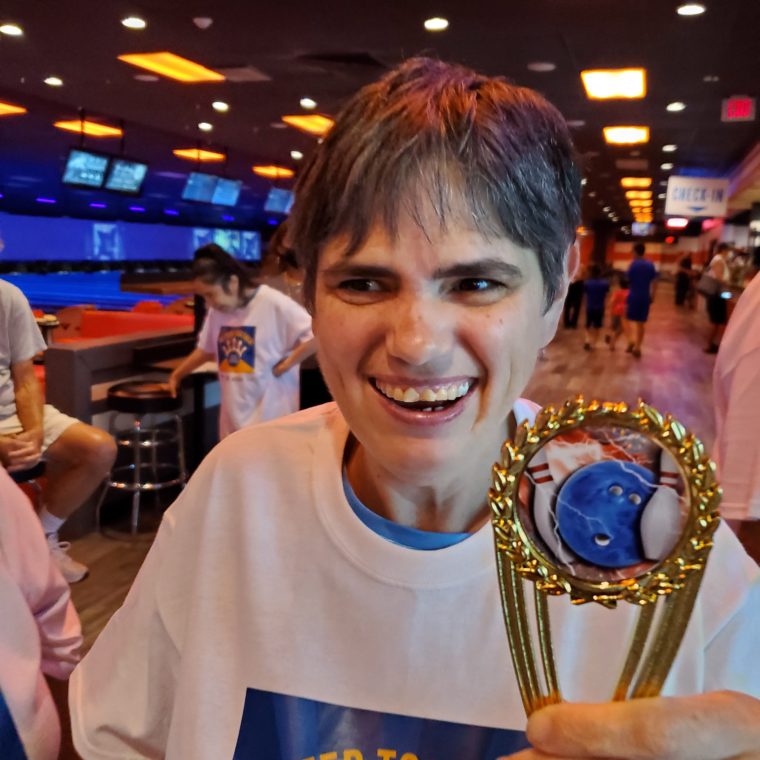 Event attendees hold participation trophies