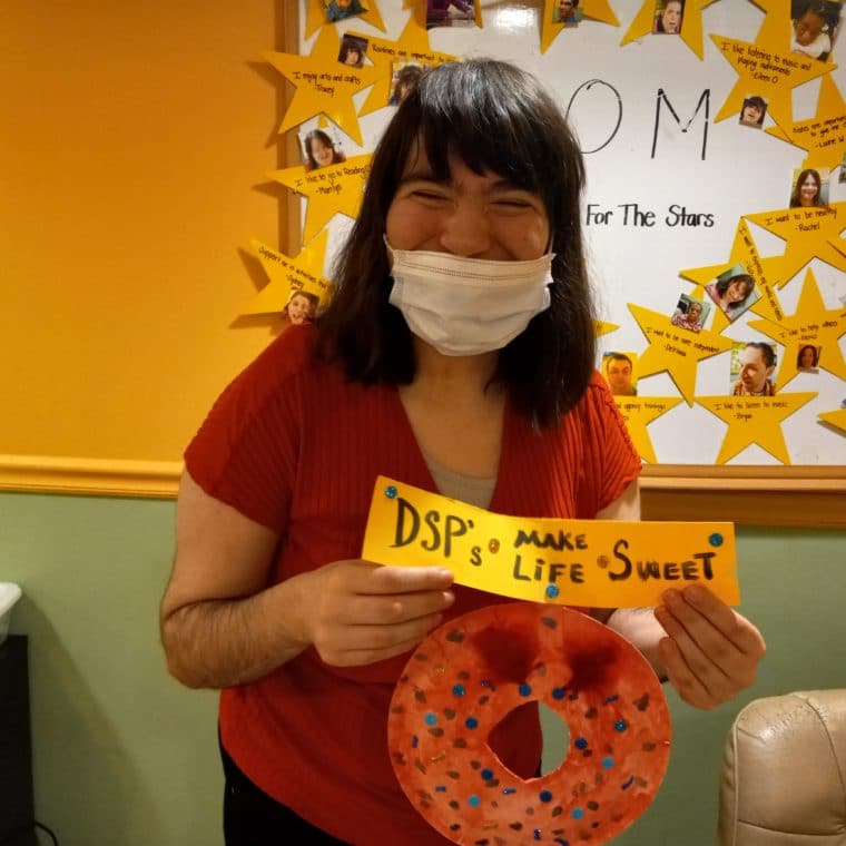 A person supported holds a sign sharing, "DSPs make life sweet."