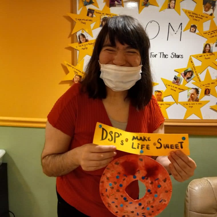 A person supported holds a sign sharing, "DSPs make life sweet."
