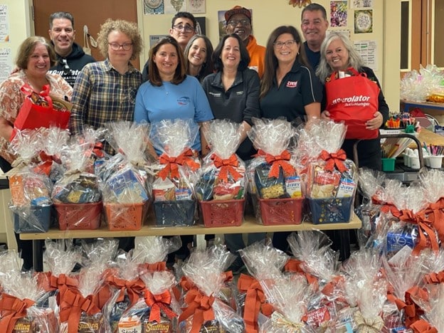 Volunteers pose with donations made to combat food insecurity on Long Island
