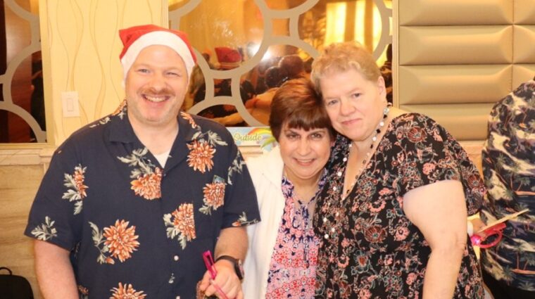 Three people supported by AHRC Nassau enjoy the Holly Jolly July party.