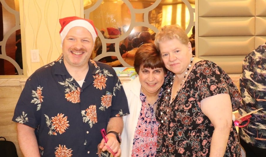 Three people supported by AHRC Nassau enjoy the Holly Jolly July party.