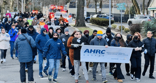 Advocates march behind AHRC banner at MLK March