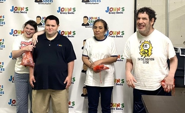 People supported pose for a photo with John from John's Crazy Socks