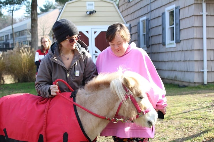 Sophie Hoffman and a staff member pose with one of Wheatley Farms' new horses, Mango & Belle