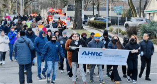 AHRC community marches behind banner at MLK Day March