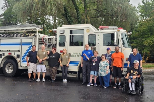 People supported pose in front of a firetruck to learn about emergency preparedness for Patriot Day.