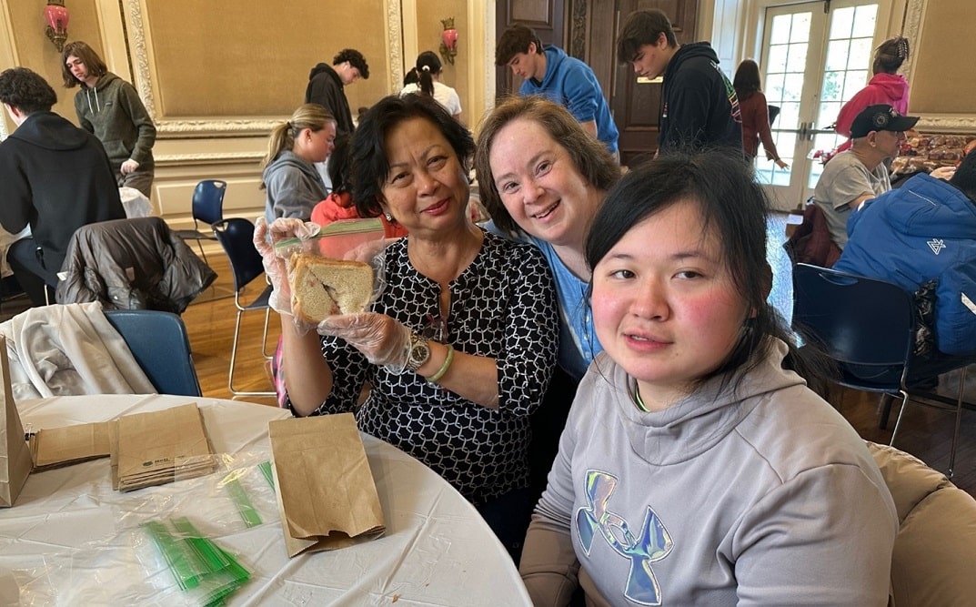 Portledge School students and AHRC Nassau day services attendees packing lunches together for a food pantry.