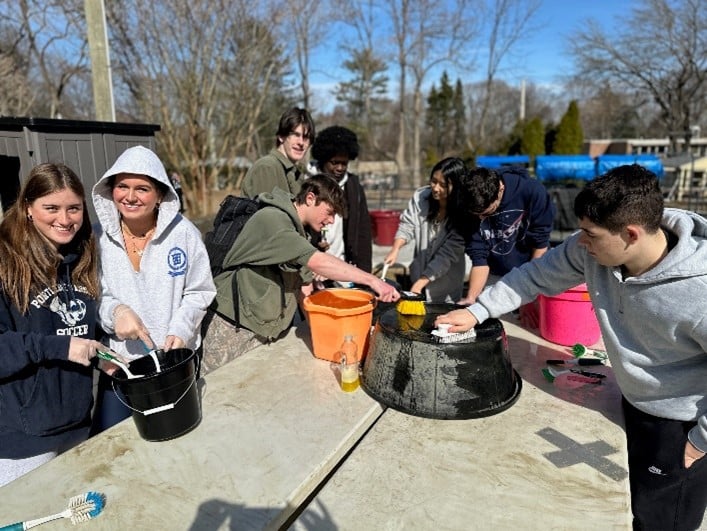 Portledge School students helping clean pots at Wheatley Farms.