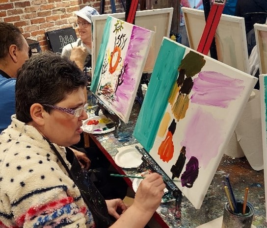 People supported at a recreational painting class