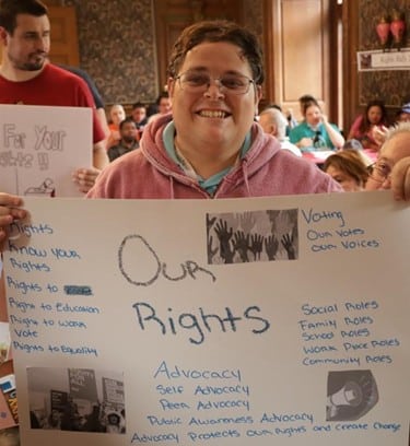 A person supported by AHRC Nassau holding a sign that reads "Our Rights" at the Rights Rally