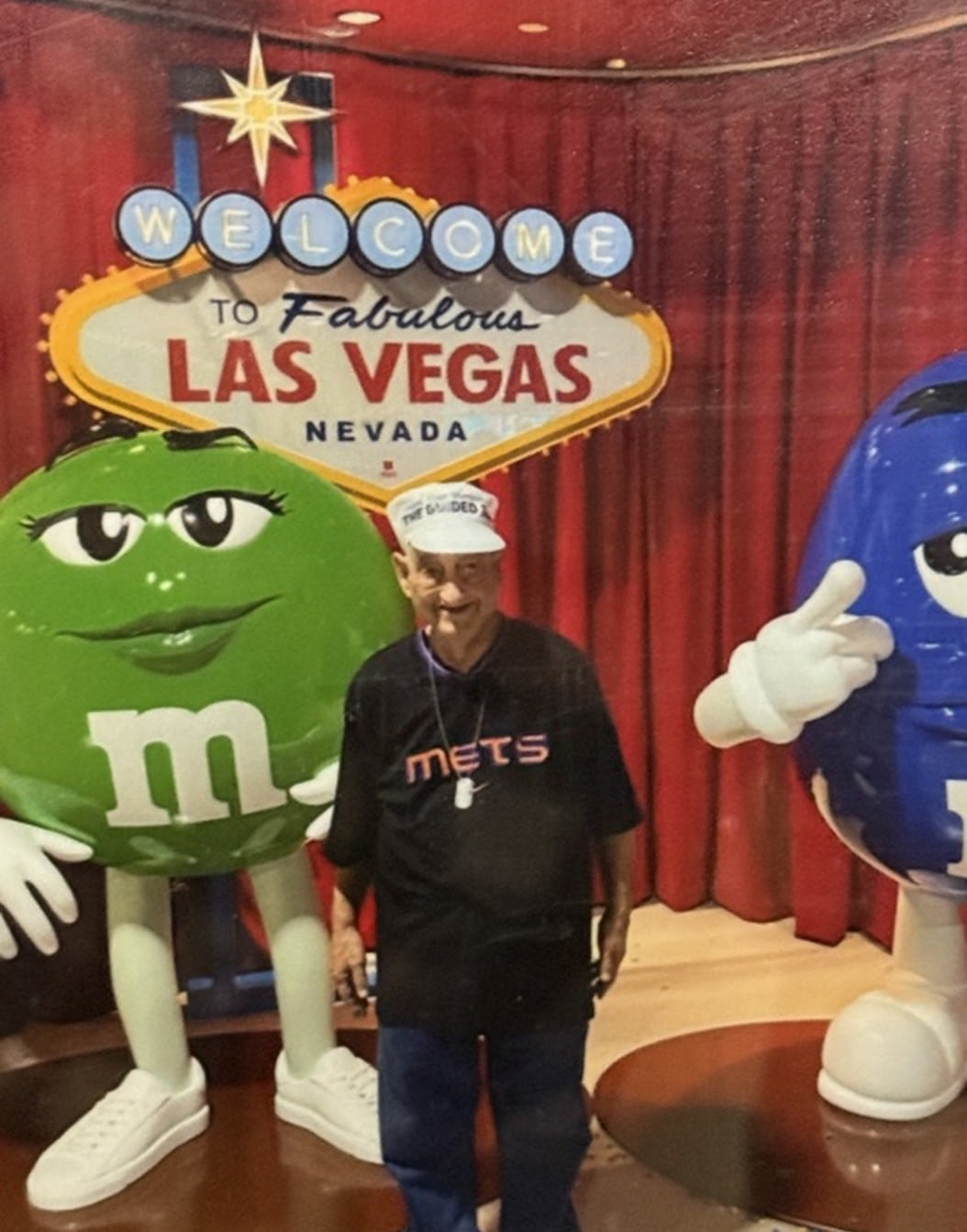 Ronald Burglass poses with a green M&M statue in Las Vegas