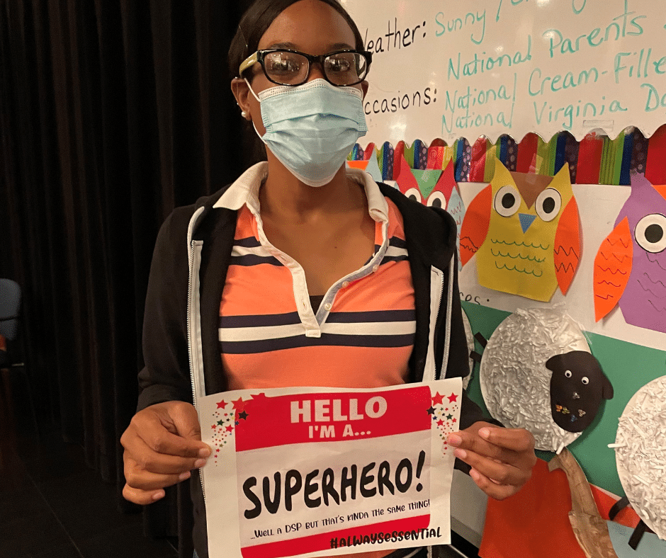 Irlande Elius, DSP, holds a sign celebrating DSP Week and her role as a superhero.