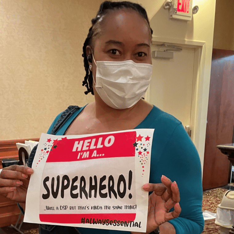 Jody Hall, DSP, holds a sign celebrating DSP Week and her role as a superhero.