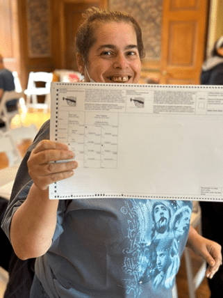 A self-advocate shows off her ballot at the Voter Demonstration rally